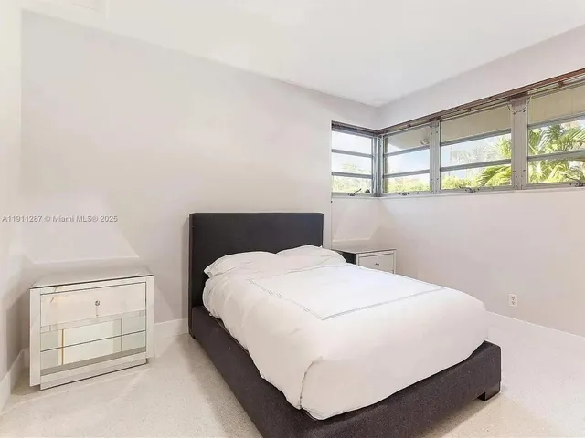 a large bed sitting in a bedroom next to a window