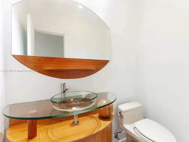 a bathroom with a granite countertop toilet and a sink