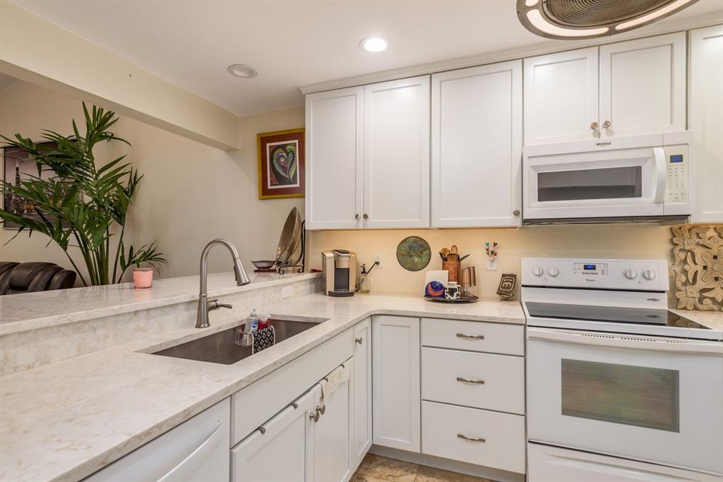 1333 McMullen Booth Road, Unit 1333 Clearwater, FL 33759 - Photo 4 of 26 a kitchen with cabinets appliances a sink and a counter top space