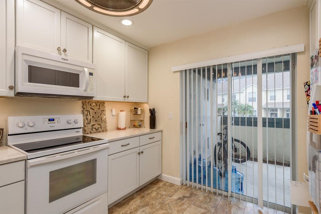 1333 McMullen Booth Road, Unit 1333 Clearwater, FL 33759 - Photo 6 of 26 a kitchen with a stove a sink and a microwave
