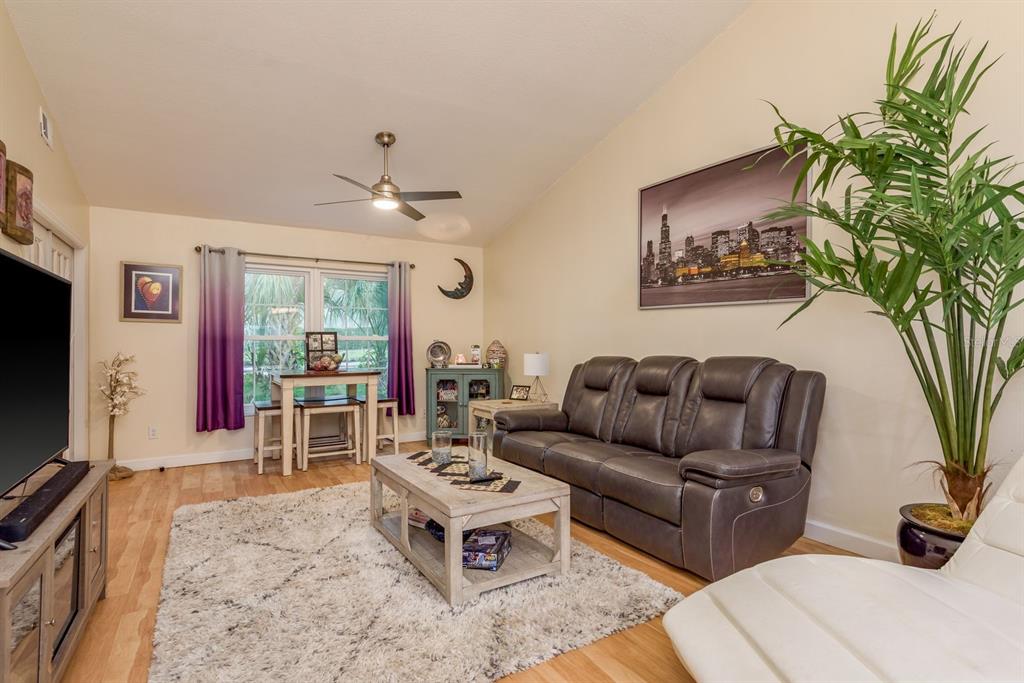 1333 McMullen Booth Road, Unit 1333 Clearwater, FL 33759 - Photo 8 of 26 a living room with furniture a flat screen tv and a potted plant
