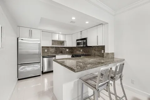 a kitchen with a refrigerator a microwave a sink and cabinets