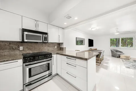 a kitchen with stainless steel appliances granite countertop a stove microwave and sink