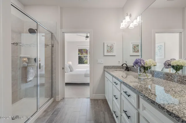 a spacious bathroom with a granite countertop sink mirror and shower