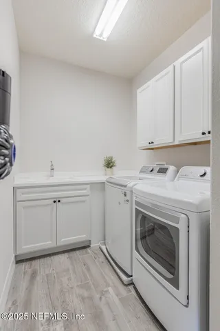 a utility room with sink dryer and washer