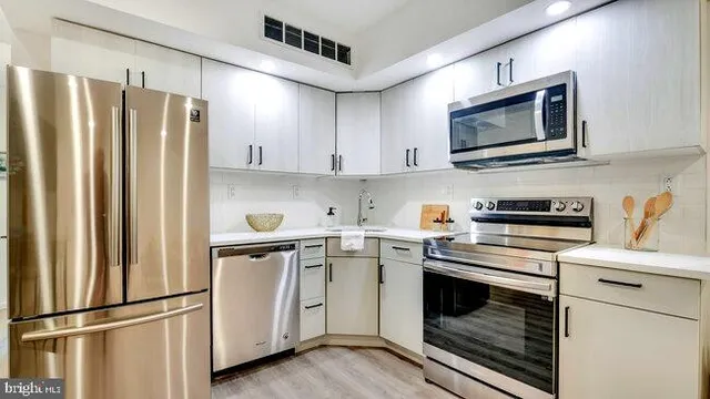 a kitchen with stainless steel appliances a refrigerator stove and microwave