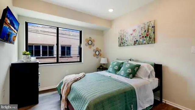 a bedroom with a bed and a painting on the wall