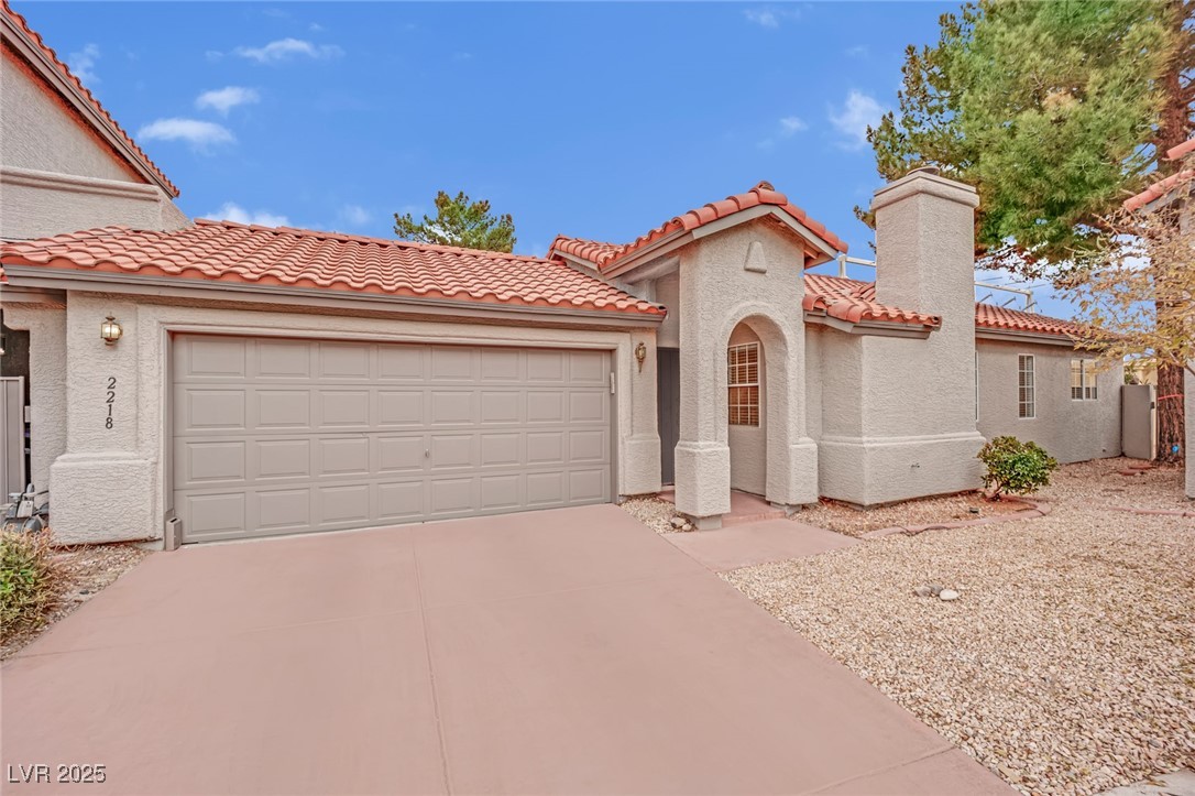 2218 Ramsgate Drive Henderson, NV 89074 - Photo 12 of 33 Mediterranean / spanish home with an attached garage, a tile roof, concrete driveway, stucco siding, and a chimney