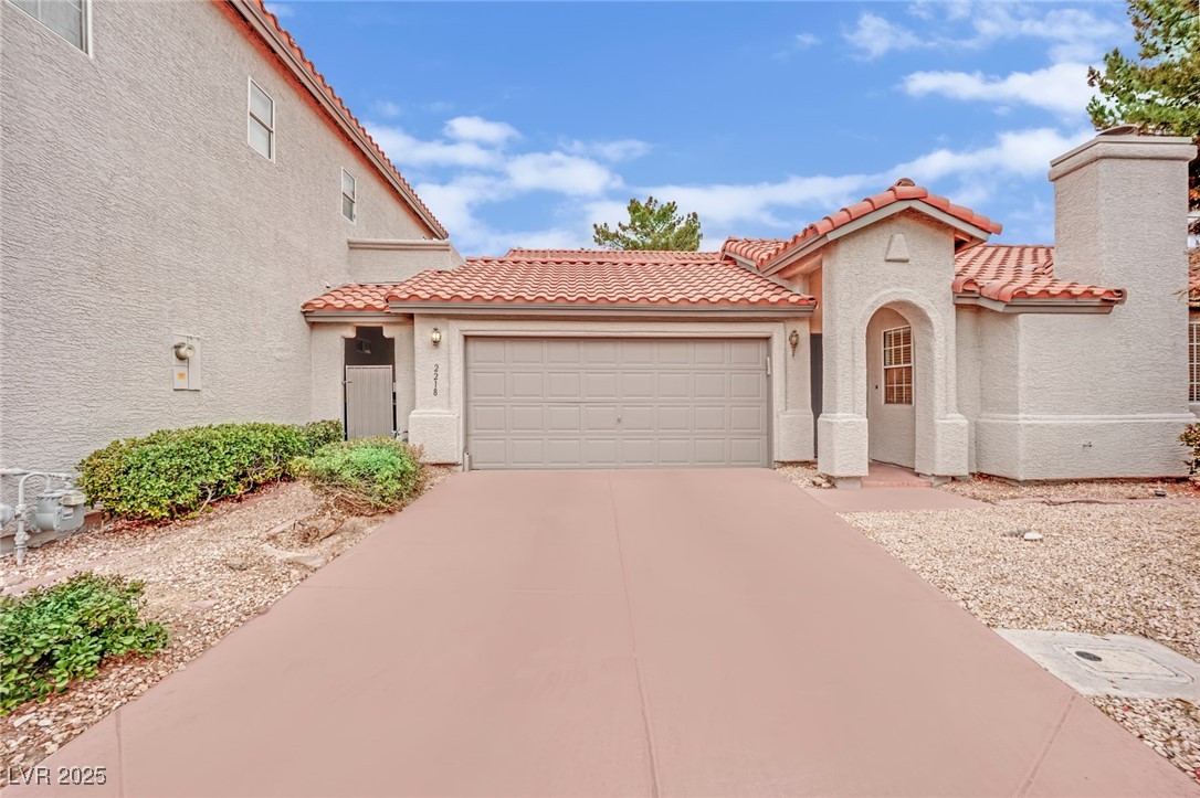 2218 Ramsgate Drive Henderson, NV 89074 - Photo 13 of 33 Mediterranean / spanish-style house featuring concrete driveway, a chimney, a tiled roof, an attached garage, and stucco siding