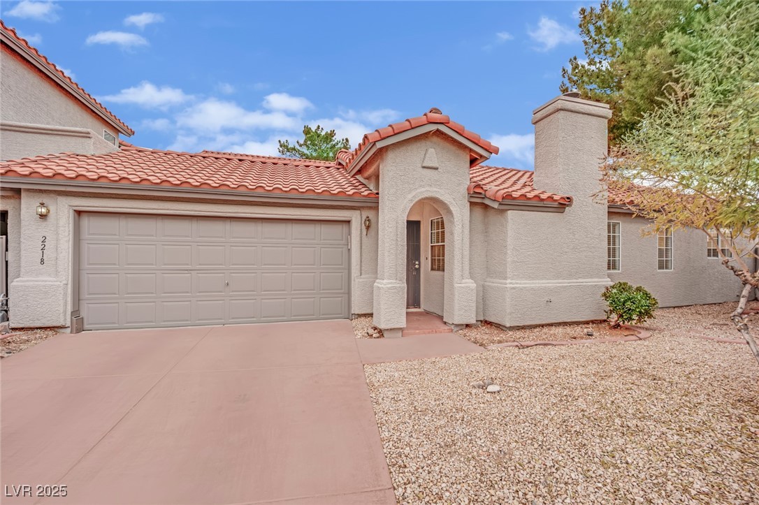 2218 Ramsgate Drive Henderson, NV 89074 - Photo 14 of 33 Mediterranean / spanish-style house featuring an attached garage, a chimney, concrete driveway, and stucco siding