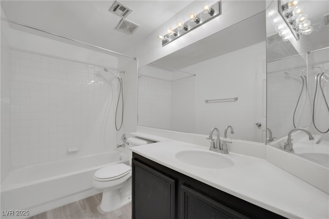 2218 Ramsgate Drive Henderson, NV 89074 - Photo 15 of 33 Full bathroom featuring visible vents, toilet, tub / shower combination, vanity, and wood finished floors