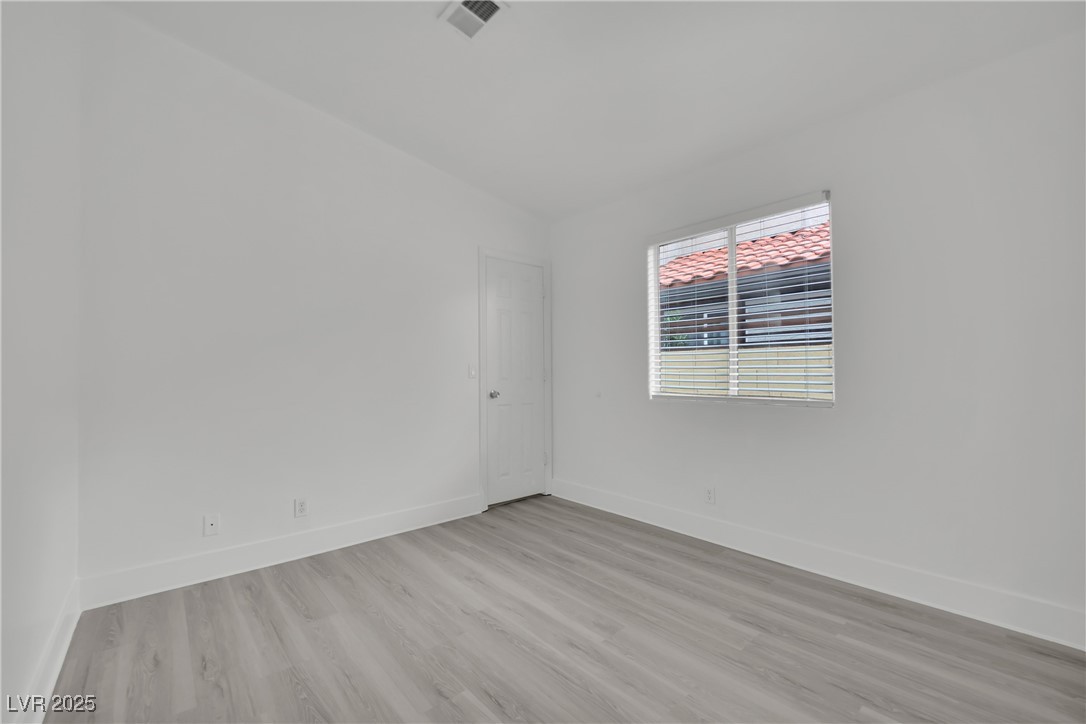 2218 Ramsgate Drive Henderson, NV 89074 - Photo 16 of 33 Empty room with light wood-type flooring, visible vents, and baseboards