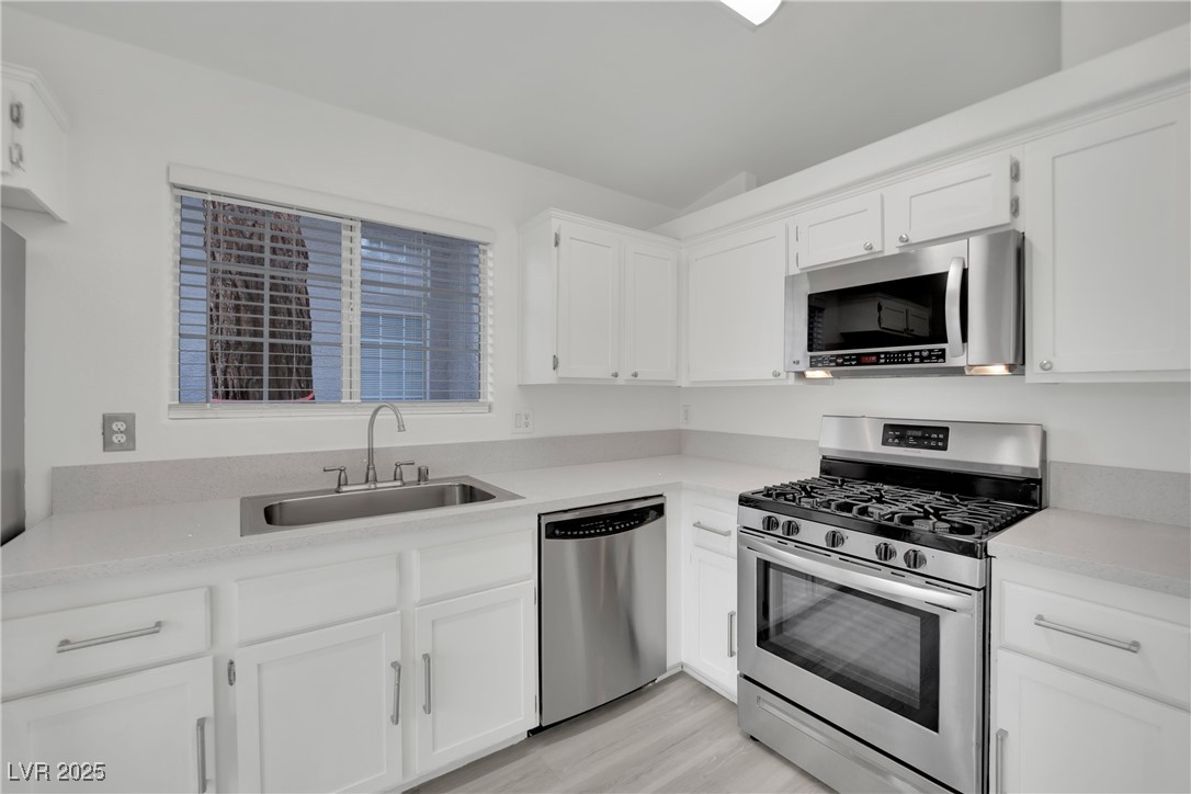 2218 Ramsgate Drive Henderson, NV 89074 - Photo 20 of 33 Kitchen featuring stainless steel appliances, a sink, and white cabinetry