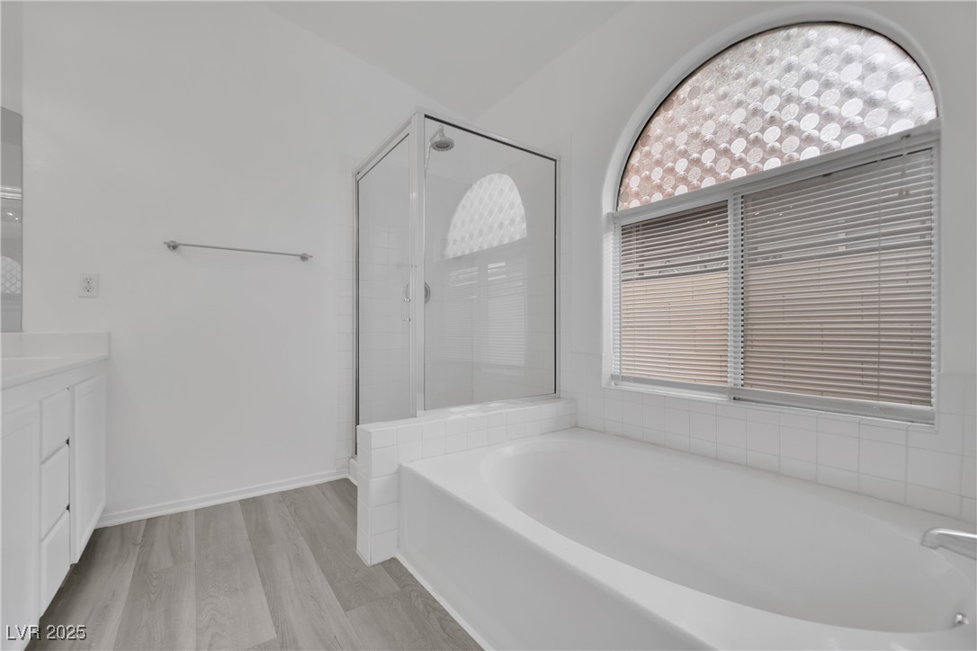2218 Ramsgate Drive Henderson, NV 89074 - Photo 23 of 33 Full bathroom with a stall shower, wood finished floors, vanity, and a bath