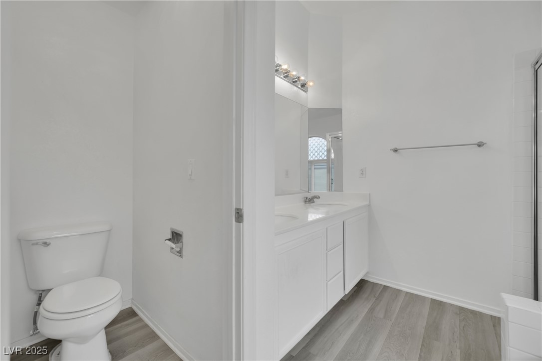 2218 Ramsgate Drive Henderson, NV 89074 - Photo 28 of 33 Full bath featuring vanity, wood finished floors, toilet, and baseboards