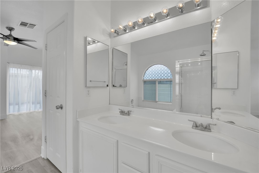 2218 Ramsgate Drive Henderson, NV 89074 - Photo 29 of 33 Bathroom featuring double vanity, a ceiling fan, visible vents, and a sink