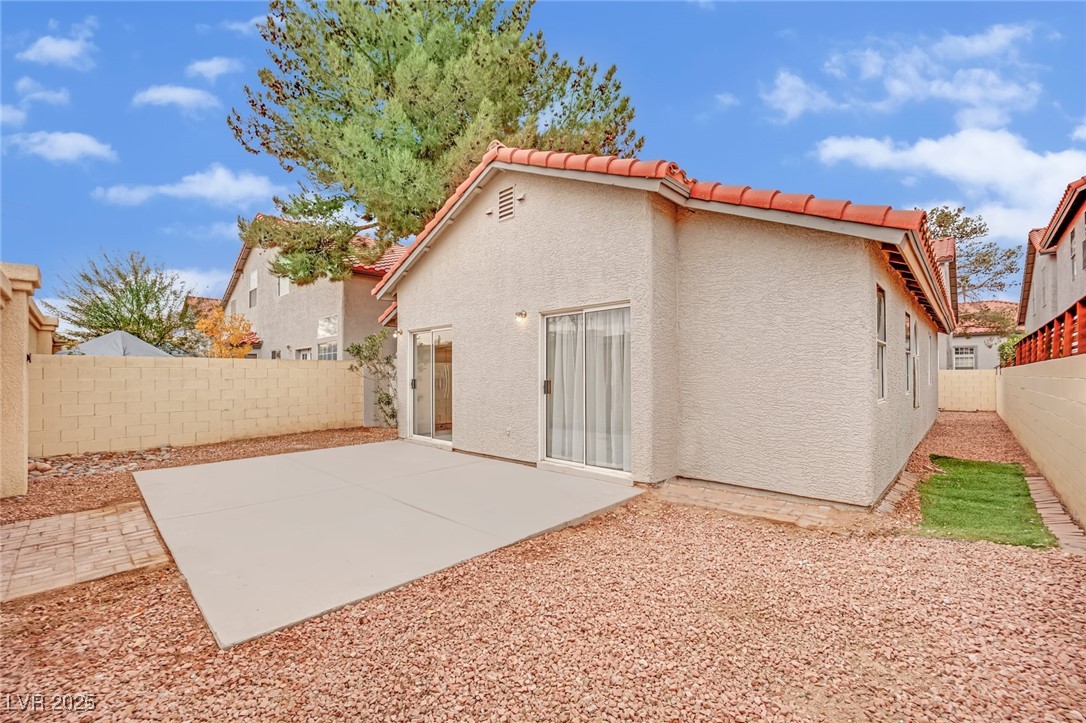 2218 Ramsgate Drive Henderson, NV 89074 - Photo 32 of 33 Rear view of property featuring a tiled roof, a patio area, a fenced backyard, and stucco siding