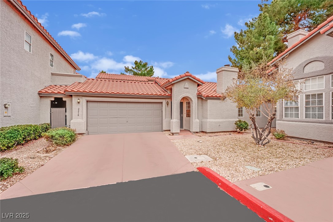 2218 Ramsgate Drive Henderson, NV 89074 - Photo 5 of 33 Mediterranean / spanish house featuring an attached garage, stucco siding, a chimney, and a tiled roof