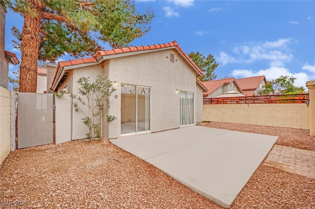 2218 Ramsgate Drive Henderson, NV 89074 - Photo 6 of 33 Rear view of property featuring a tiled roof, a patio area, a fenced backyard, and stucco siding