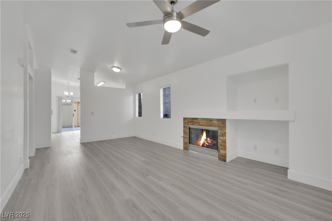 2218 Ramsgate Drive Henderson, NV 89074 - Photo 9 of 33 Unfurnished living room with baseboards, a fireplace, and light wood finished floors