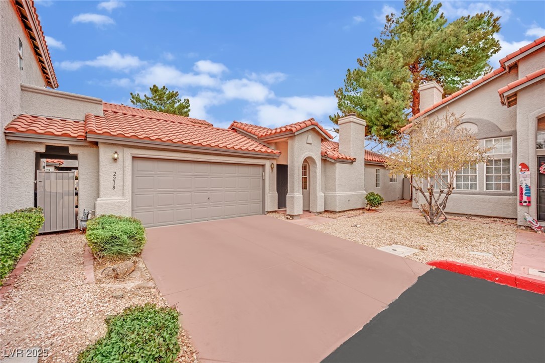 2218 Ramsgate Drive Henderson, NV 89074 - Photo 10 of 33 Mediterranean / spanish-style house with a chimney, stucco siding, an attached garage, driveway, and a tiled roof