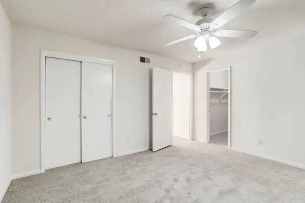 an empty room with a ceiling fan and a window