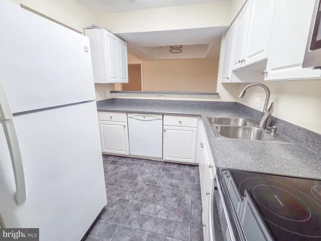 a kitchen with a sink a refrigerator and a stove