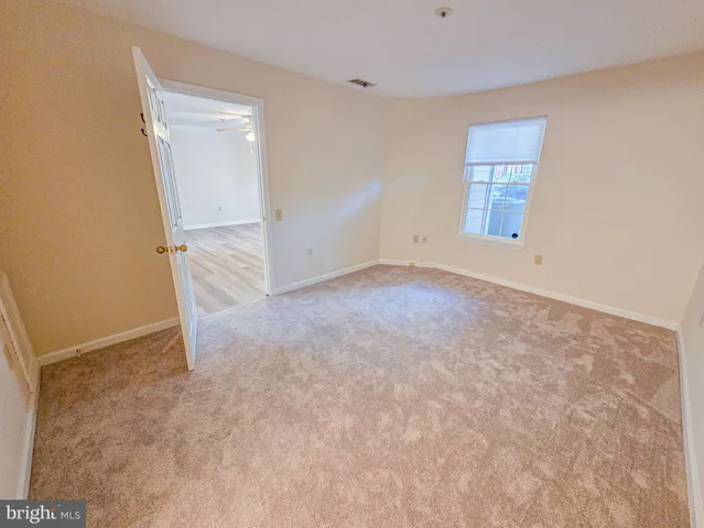 an empty room with windows and mirror