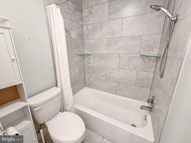 a bathroom with a toilet and a shower