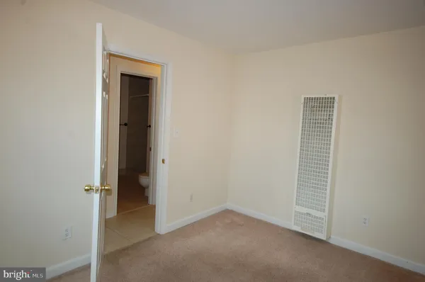 an empty room with closet and a ceiling fan