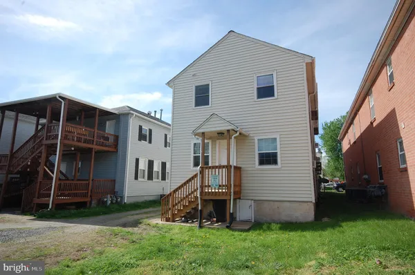 a view of a house with a yard and stairs