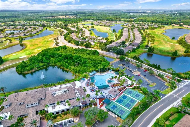 an aerial view of residential houses with outdoor space and lake view