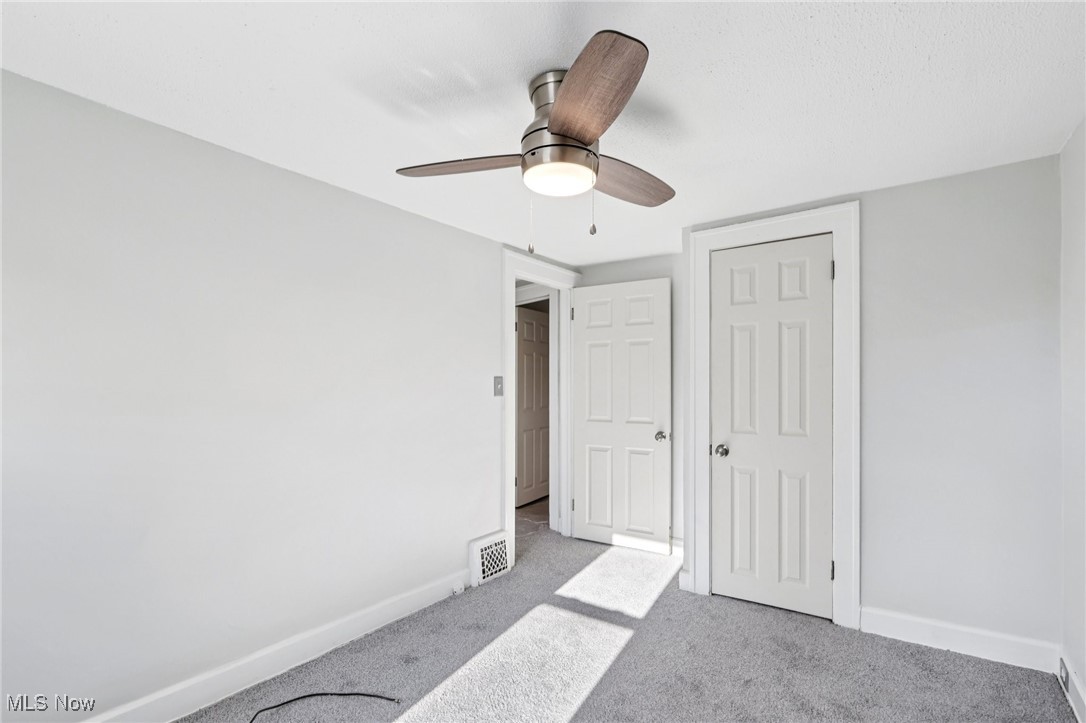 1469 South Noble Road Cleveland, OH 44121 - Photo 20 of 29 Unfurnished bedroom with carpet, a closet, and ceiling fan