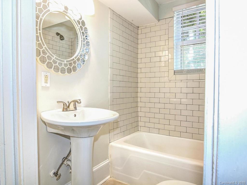 226 Providence Road Charlotte, NC 28207 - Photo 11 of 13 a bathroom with a sink a mirror a bathtub and shower