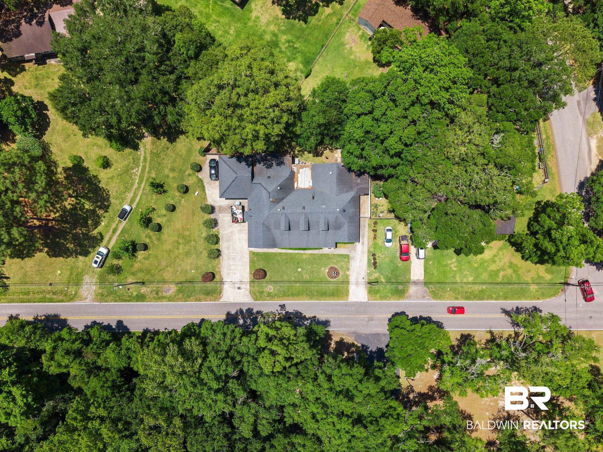 927 Cleveland Road Saraland, AL 36571 - Photo 77 of 80 Aerial perspective of a property featuring a multi-gabled roofline and two distinct concrete driveways