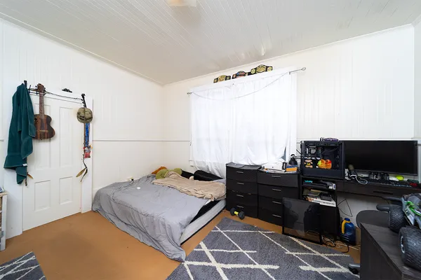 a bed sitting in a bedroom and a large mirror