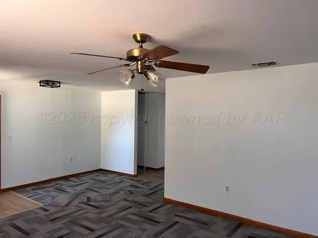 a view of a room with wooden floor and ceiling fan