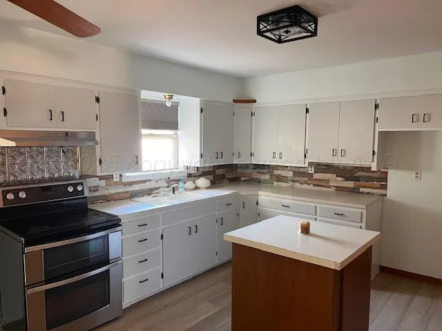 a kitchen with a sink stove and cabinets