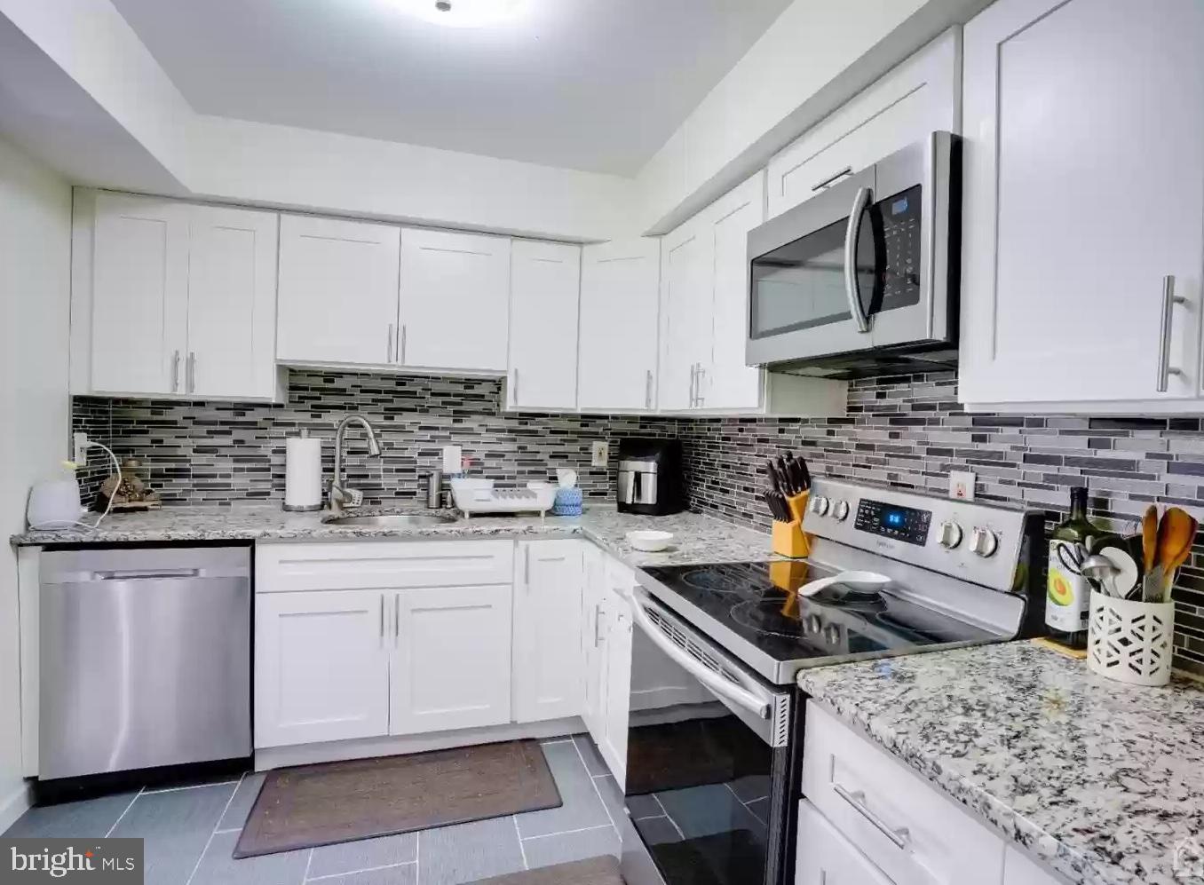 3121 Sayre Drive Princeton, NJ 08540 - Photo 7 of 10 a kitchen with stainless steel appliances granite countertop a sink stove and microwave