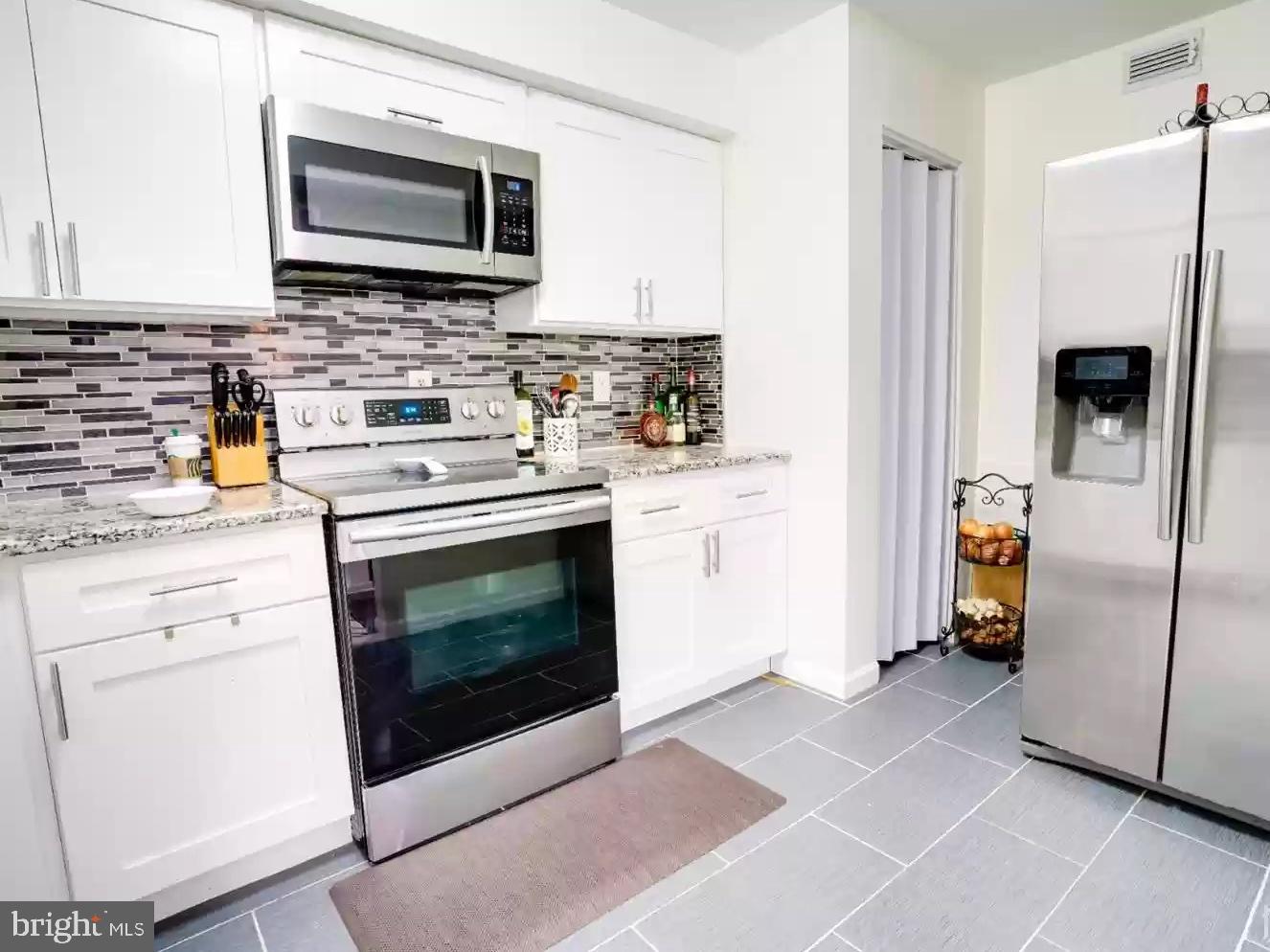 3121 Sayre Drive Princeton, NJ 08540 - Photo 8 of 10 a kitchen with stainless steel appliances a stove a microwave and a refrigerator