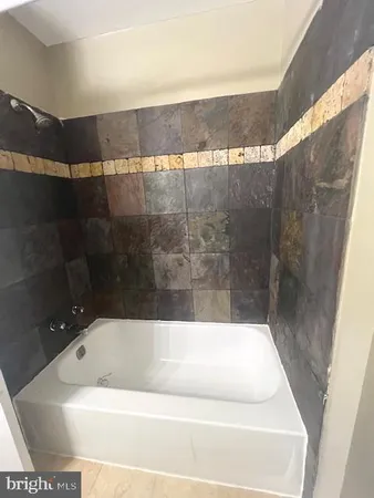 a bath tub sitting in a bathroom next to a sink