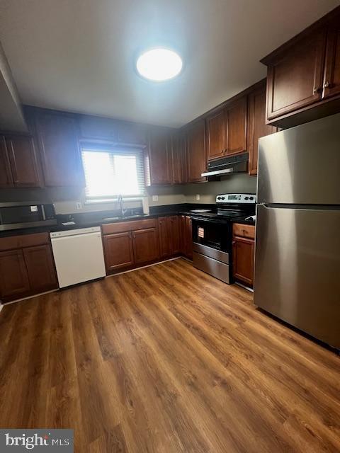 16 Brian Court, Unit 245 Gaithersburg, MD 20877 - Photo 4 of 22 a large kitchen with stainless steel appliances granite countertop a refrigerator a stove a sink dishwasher and wooden cabinets with wooden floor
