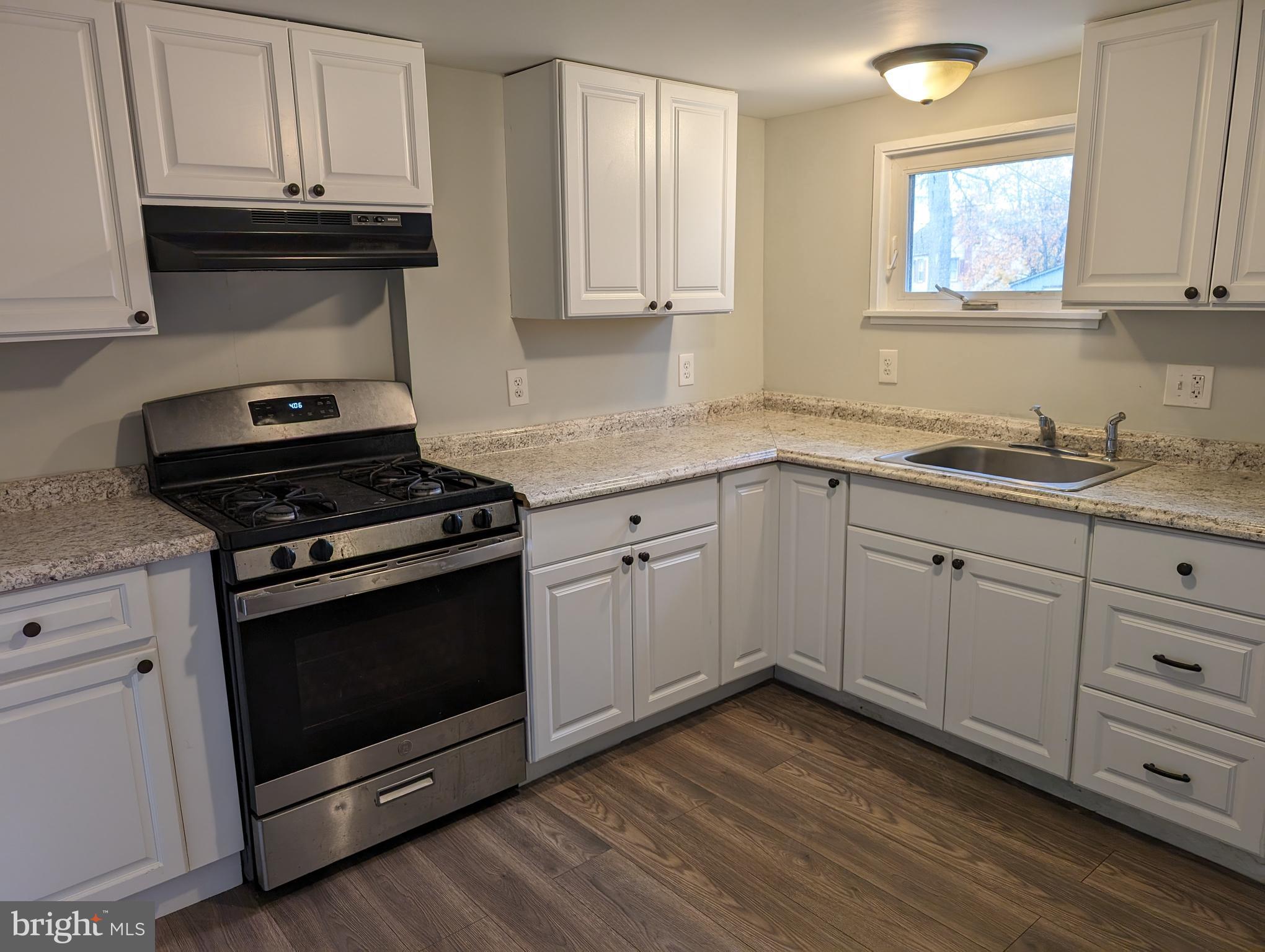 a kitchen with granite countertop a stove and a sink