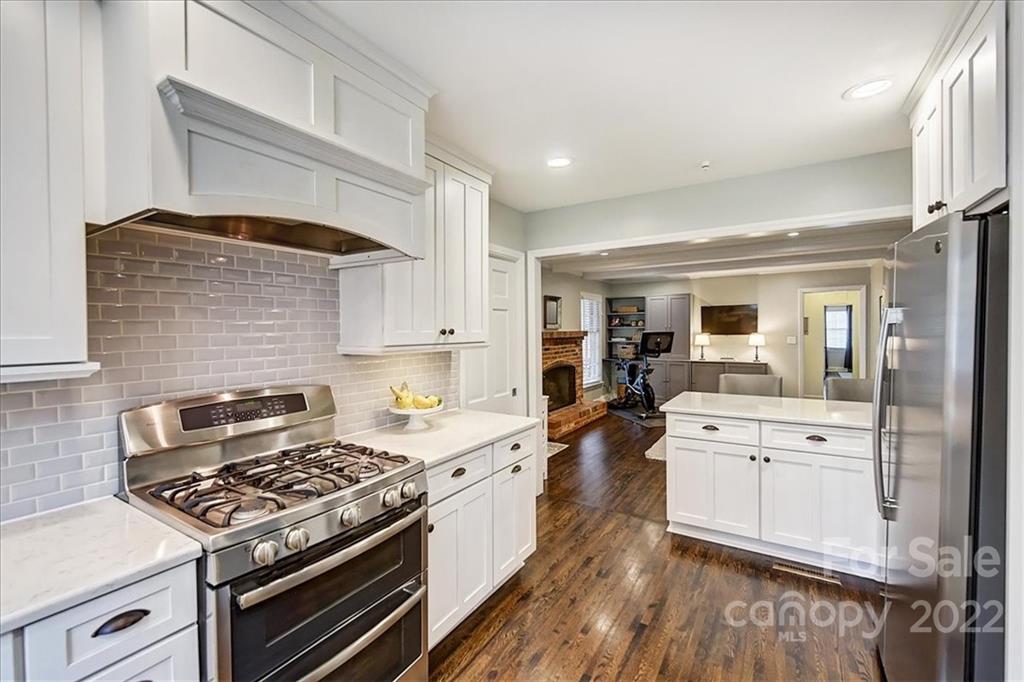 3021 Eastburn Road Charlotte, NC 28210 - Photo 23 of 48 a kitchen with stove a sink dishwasher and white cabinets with wooden floor