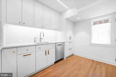 a kitchen with white cabinets and white appliances