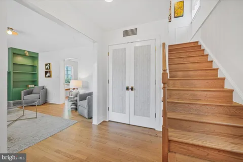 a view of a hallway with wooden floor and furniture