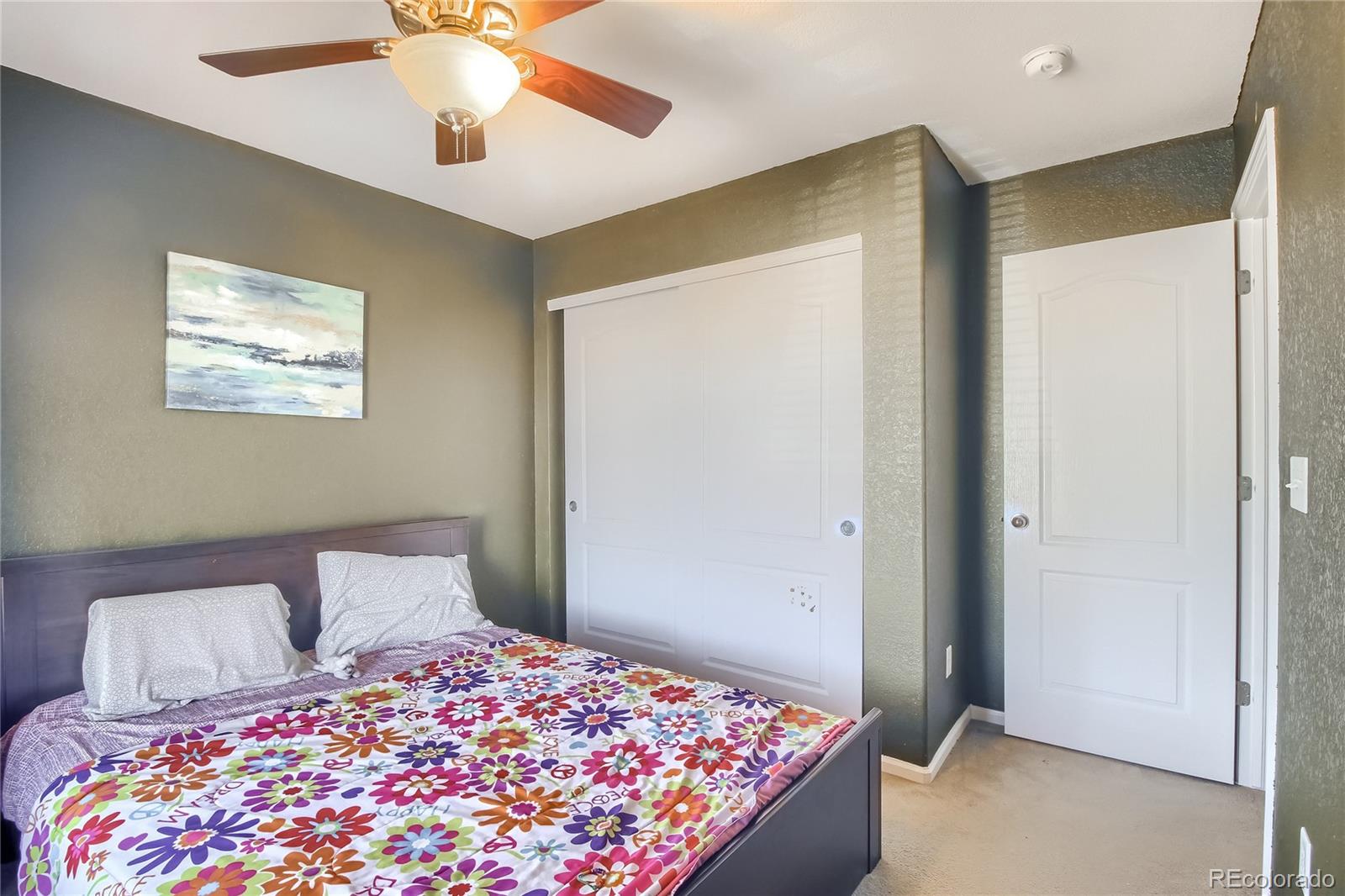 10861 Brooklawn Road Highlands Ranch, CO 80130 - Photo 17 of 30 a bedroom with a bed and a chandelier