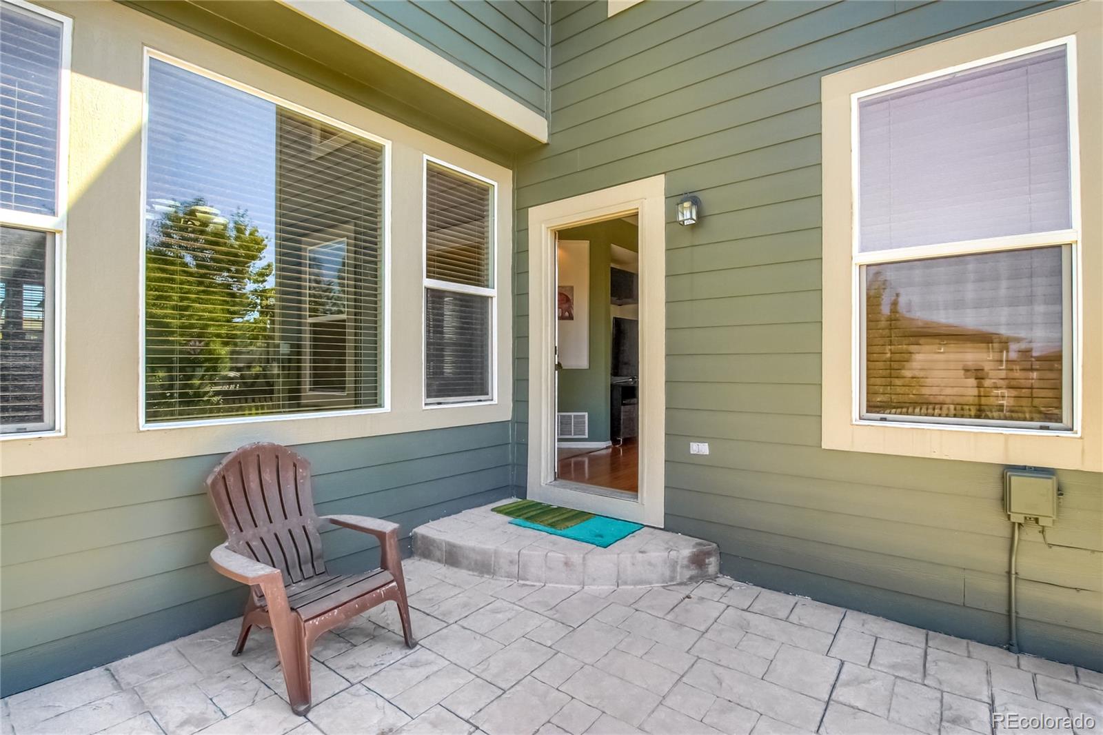 10861 Brooklawn Road Highlands Ranch, CO 80130 - Photo 29 of 30 a front view of a house with a chairs and table in a porch
