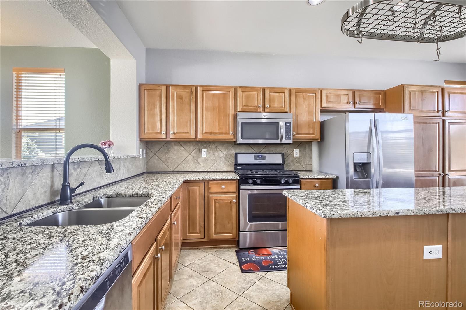 10861 Brooklawn Road Highlands Ranch, CO 80130 - Photo 8 of 30 a kitchen with stainless steel appliances granite countertop a sink stove and refrigerator