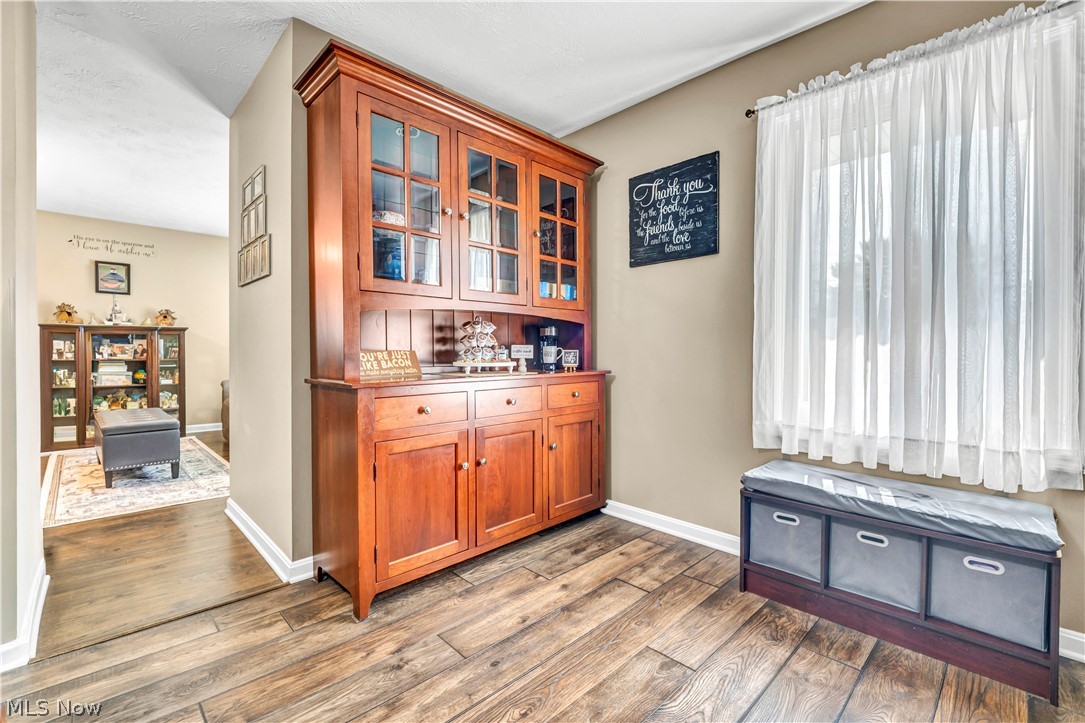 977 Lloyd Road Wickliffe, OH 44092 - Photo 12 of 38 Wood-finish flooring, built-in wooden hutch with glass-front cabinetry, window with natural light, neutral wall colors, white trim